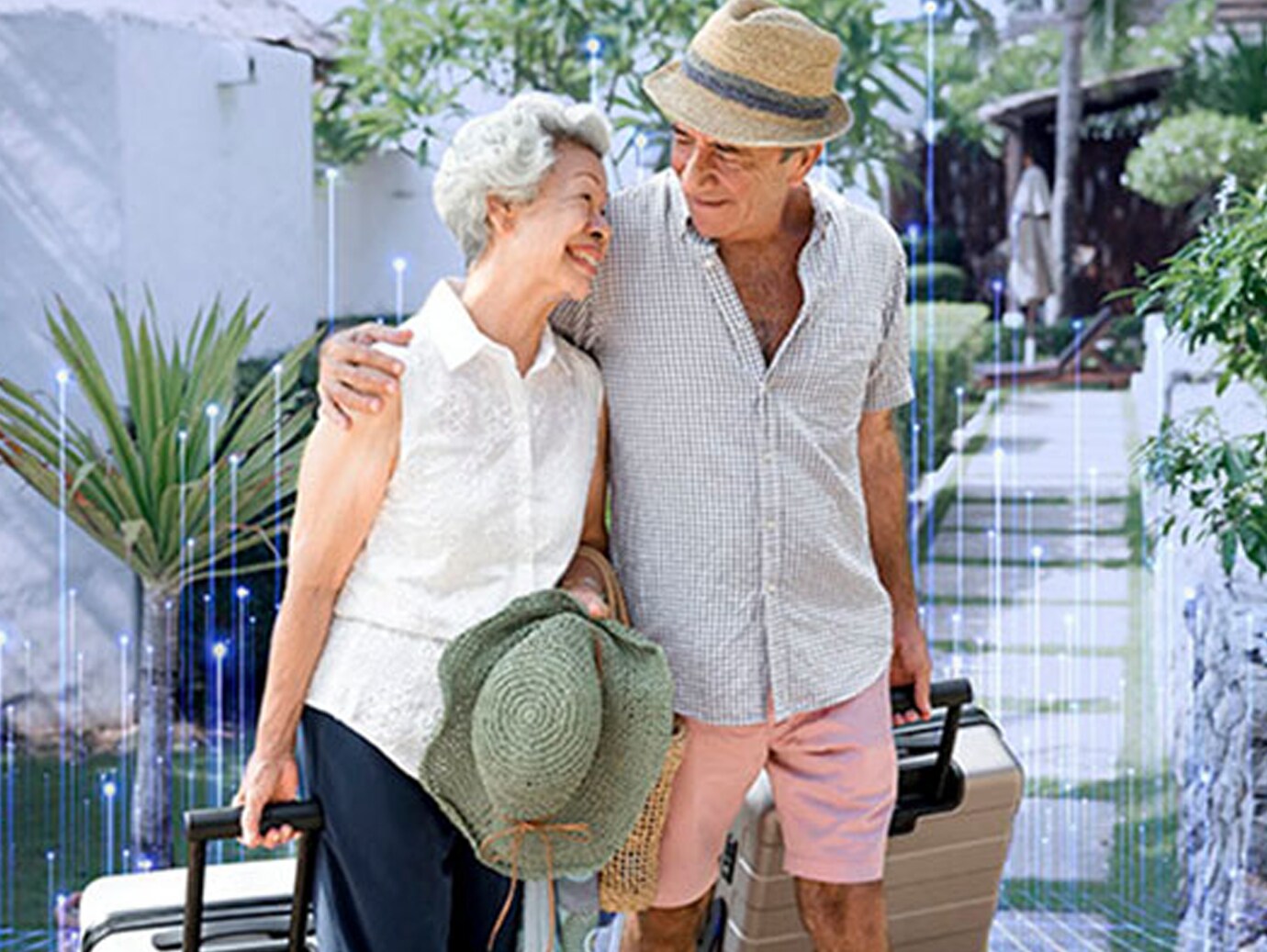 An elderly couple smiling and carrying luggage 